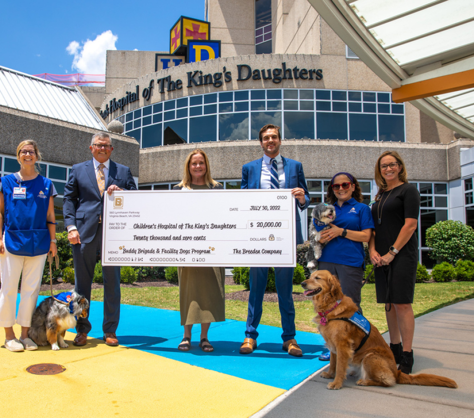 Breeden and CHKD staff holding big donation check outside of hospital